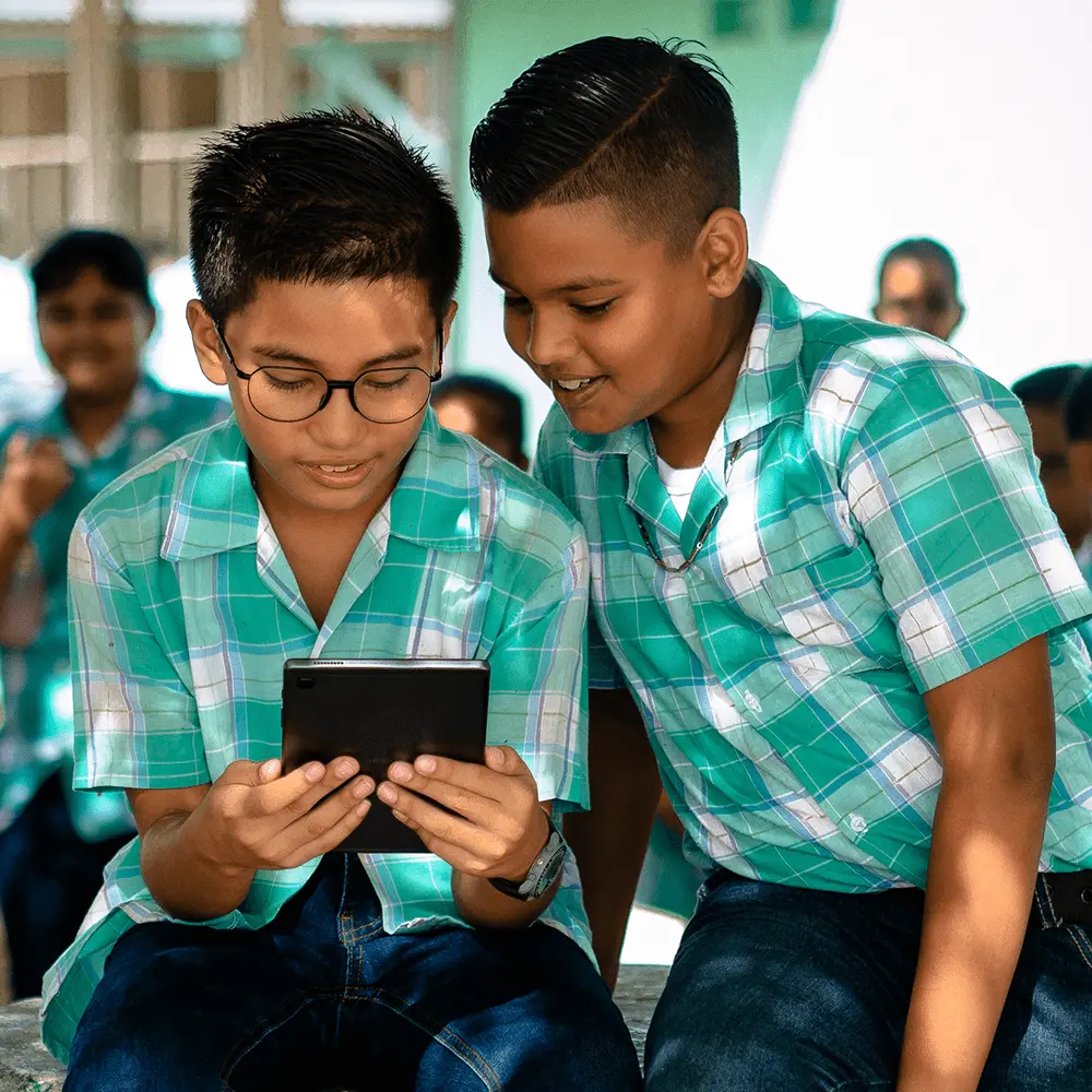 Twee kinderen op school kijken naar een tablet